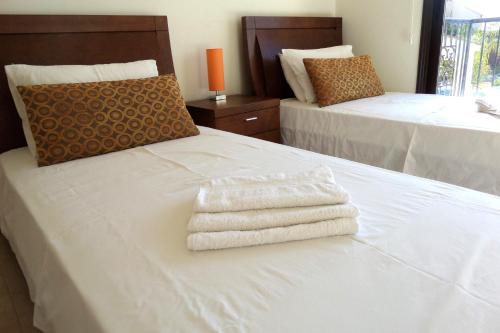 a bedroom with two beds with white towels on them at Modern 3 bedroom villa, pool and close to golf course in Paphos City