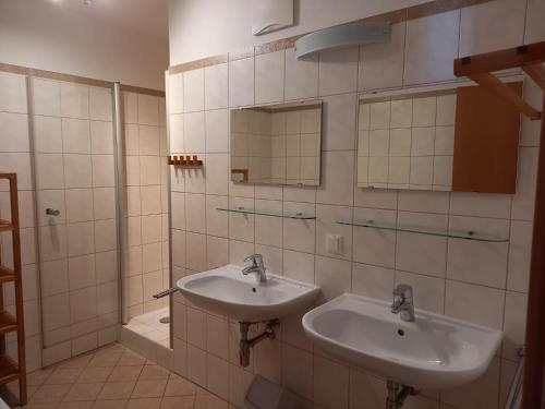 a bathroom with two sinks and a shower at Haus Aineckblick, Liftstrasse 250, Top 3 in Sankt Margarethen im Lungau