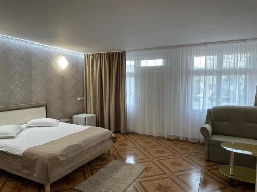 a bedroom with a bed and a couch and a chair at Dany Holiday in Eforie Nord