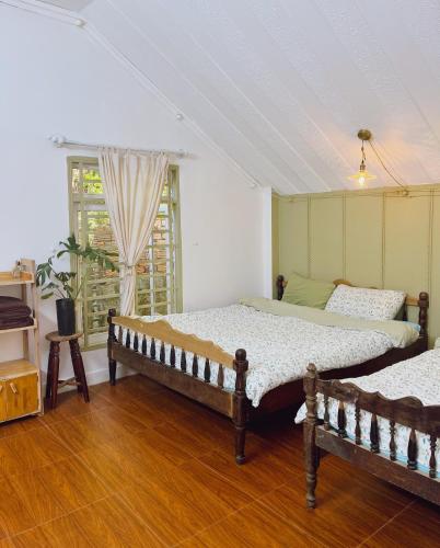 a bedroom with two beds and a window at Góc sân và Khoảng trời 2 - Đặng Thái Thân (phòng lẻ) in Xuan An