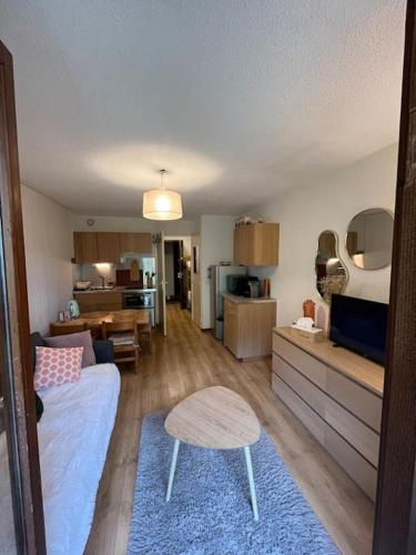 un salon avec un canapé et une table dans l'établissement Studio au pied des pistes, à Demi-Quartier