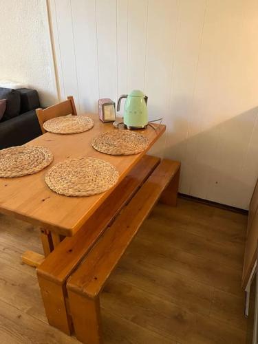une table en bois avec quatre pizzas et une bouilloire dessus dans l'établissement Studio au pied des pistes, à Demi-Quartier