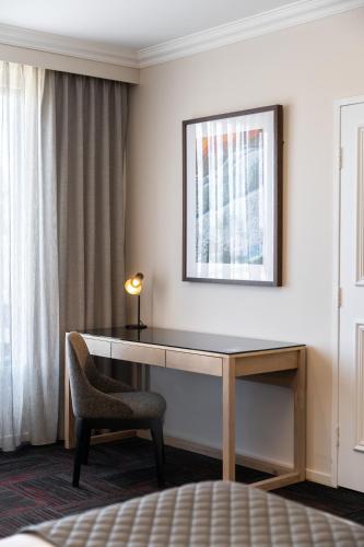 a desk in a hotel room with a chair and a window at Quality Hotel Parklake Shepparton in Shepparton
