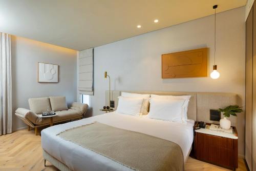 een hotelkamer met een groot bed en een bank bij Jewel TLV Hotel in Tel Aviv