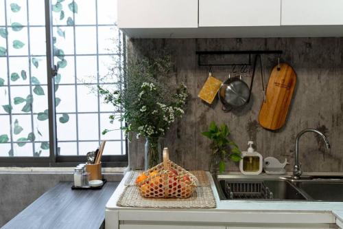 a kitchen with a sink and a bowl of fruit on a counter at 2 Bedroom Industrial Apartment in Central Saigon in Ho Chi Minh City