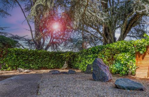 a garden with rocks and a hedge and trees at Zen Haus Garden Retreat, prime location, Luxe amenities in Eugene