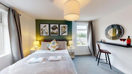 a bedroom with a bed with two pillows on it at Stylish Duplex Apartment with Home Office in Newport