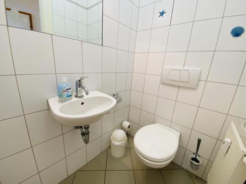 uma casa de banho branca com um WC e um lavatório em Villa Diana/Windrose em Warnemünde