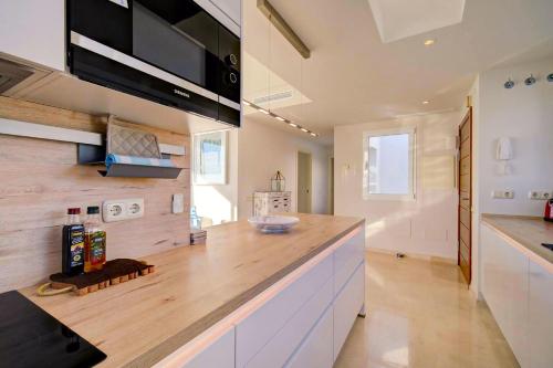 uma cozinha com um balcão de madeira num quarto em Luxury Penthouse Alcazaba Lagoon 521 EHHouse em Estepona