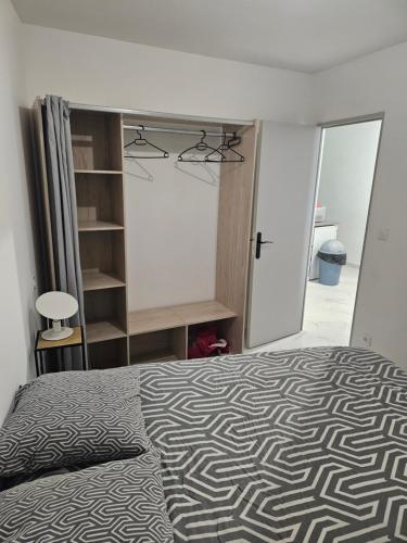 une chambre avec un lit avec une couverture noire et blanche dans l'établissement T2 moderne, calme et entièrement rénové., à Béziers