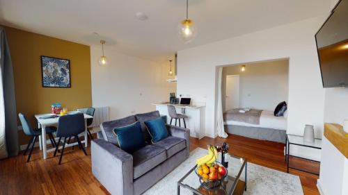 a living room with a couch and a room with a bed at Studio Apartment with 65" Smart TV in Newport