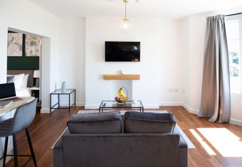 a living room with a couch and a table at Studio Apartment with 65" Smart TV in Newport