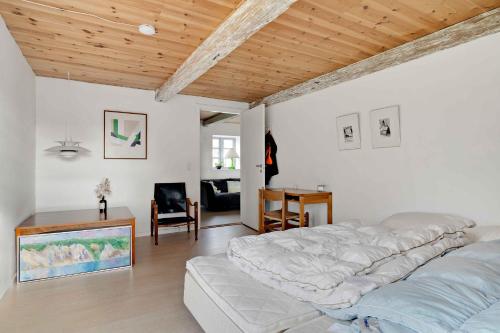 1 dormitorio con 1 cama grande y techo de madera en Cozy And Functional House By The Baltic Sea en Stege