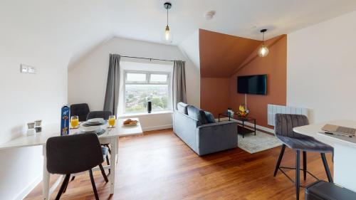 un soggiorno con divano e tavolo di Stylish Loft Apartment with View a Newport