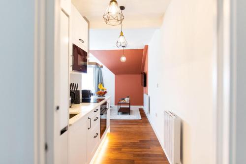 a kitchen with white cabinets and red walls at Stylish Loft Apartment with View in Newport