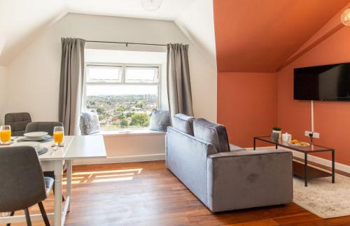 a living room with orange walls and a table and chairs at Stylish Loft Apartment with View in Newport
