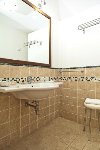 a bathroom with a sink and a mirror at Pausania Inn in Tempio Pausania