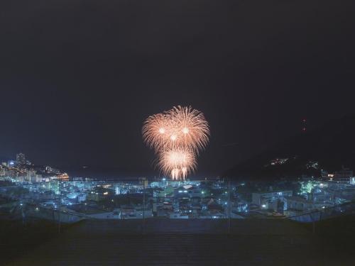 a firework in the sky over a city at night at SOKI ATAMI in Atami