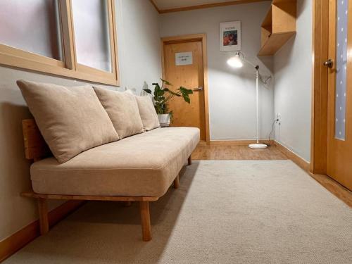 uma sala de estar com um sofá e um candeeiro de chão em Hongdae Luxury Private Single House with Big Open Balcony Perfect for a Family & Big Group 3BR, 5QB & 1SB, 2Toilet em Seul