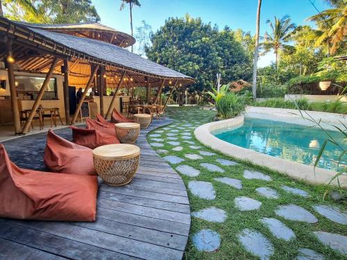 a wooden deck with pillows next to a swimming pool at Nusava Boutique Hotel in Nusa Penida