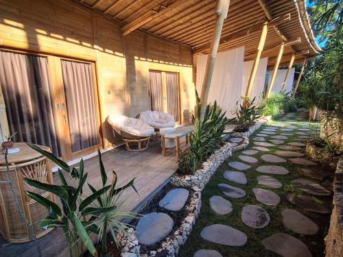 a porch of a house with a bench and plants at Nusava Boutique Hotel in Nusa Penida