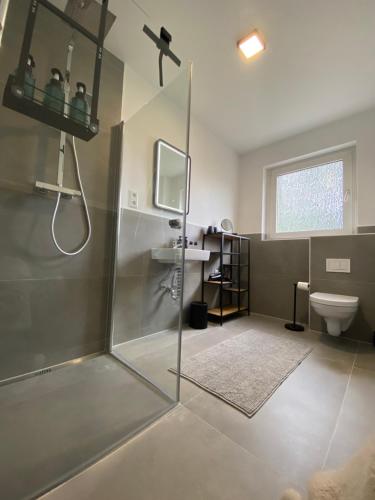 uma casa de banho com um chuveiro e um WC. em 2Br freeParking DUS Airp DUS Ess NTFLX em Wuppertal
