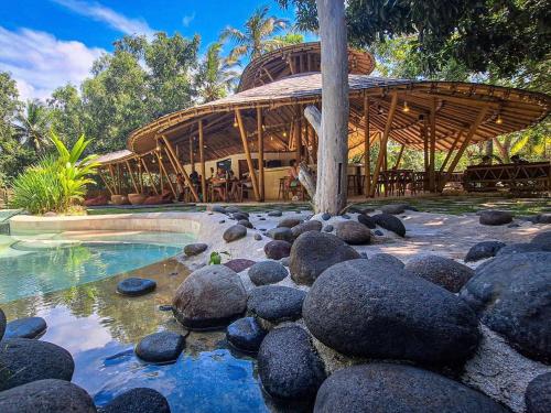 a swimming pool with rocks in front of a building at Nusava Boutique Hotel in Nusa Penida