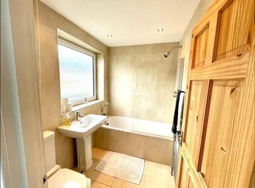 uma casa de banho com um lavatório, um WC e uma banheira em *Family Home in Mumbles. Close to the Beach* em The Mumbles