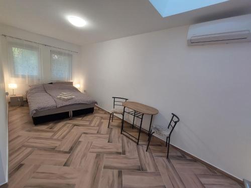 1 dormitorio con 1 cama y suelo de madera en Szépasszonyvölgy Apartman, en Eger