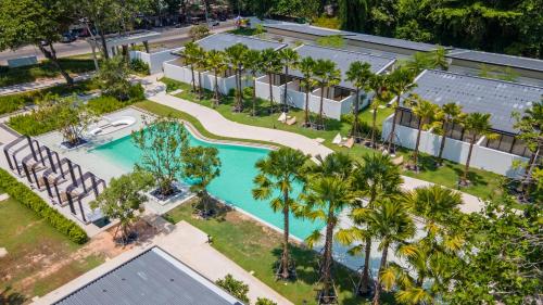 an aerial view of a resort with a swimming pool and palm trees at The Season Resort in Ban Chamrung