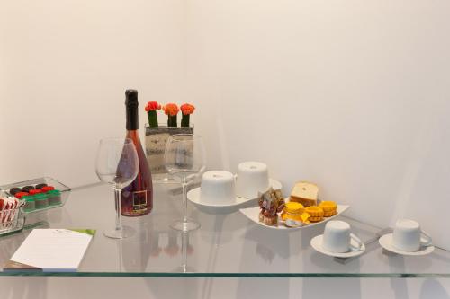 a glass table with a bottle of wine and a plate of food at Estate4home - Surreo Luxury B&b in Sorrento