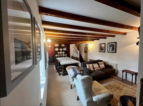 Cosy cottage in peaceful location في سوانسي: غرفة معيشة مع أريكة وكراسي وطاولة