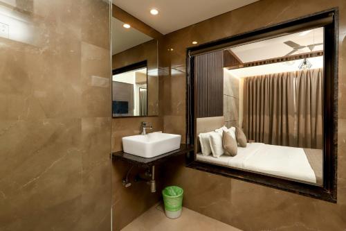 a bathroom with a sink and a mirror at Zaras Resort Khandala in Lonavala
