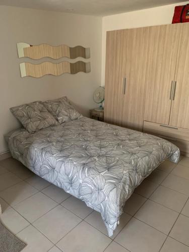Schlafzimmer mit einem Bett und einem Holzschrank in der Unterkunft Studio martigues in Martigues