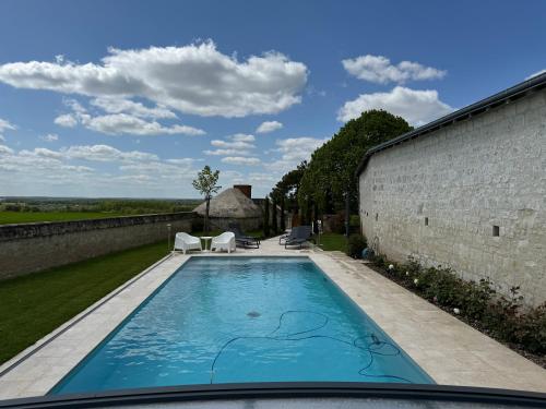 a swimming pool in the backyard of a house at Le Lodge de Richard, studio indépendant in Marçay