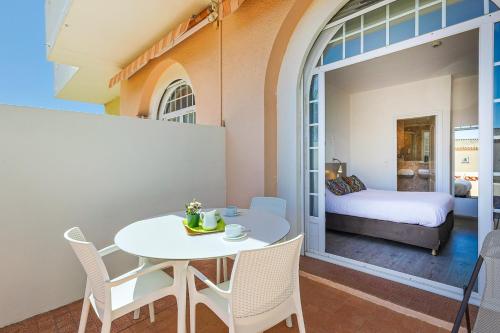 a room with a table and chairs and a bedroom at Logis Hotel l'Esterella in Agay - Saint Raphael