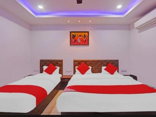 a bedroom with two beds with red and white sheets at Hotel SS palace in Bijnaur