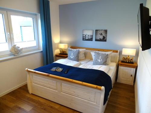 a bedroom with a large bed with a blue blanket at Gode Wind Quartiere 1 in Dahme