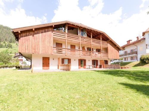a large building with a grass field in front of it at Spacious Chalet with Garden near Ski Area in Tyrol in Pozza di Fassa