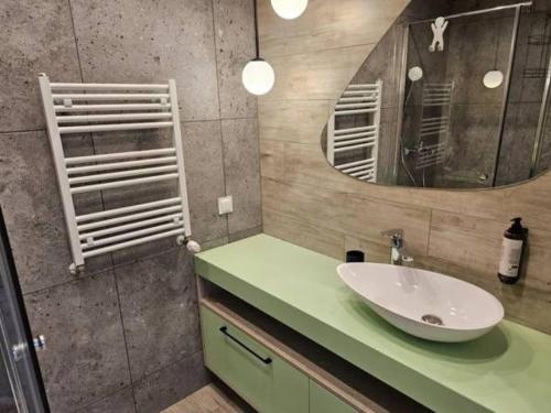 a bathroom with a sink and a mirror at Apartament z widokiem na port in Mrzeżyno