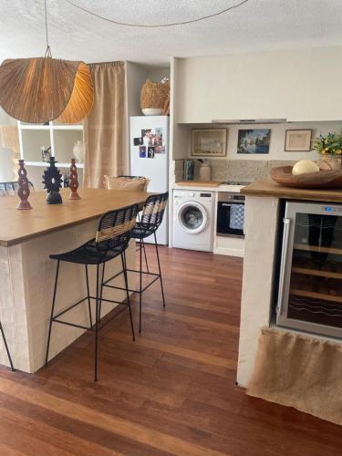 - une cuisine avec un comptoir et deux tabourets dans une pièce dans l'établissement Appartement le Raphaël, à Villeneuve-lès-Avignon