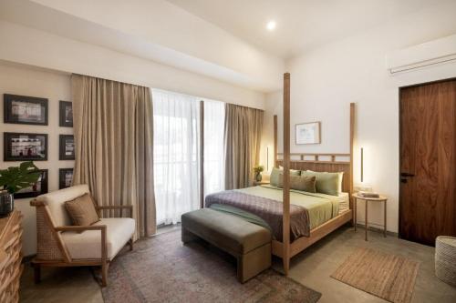 a bedroom with a bed and a chair and a window at 3BHK Villa With Private Pool & Concierge in Asagao in Assagao