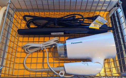 a wire basket with a hair dryer and other items at Habitacion Cottage Jin in Azagawa