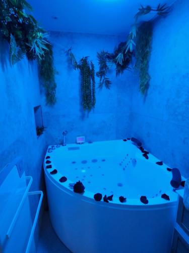 a white tub in a room with a blue light at Zen room - Havre de paix in Hyères