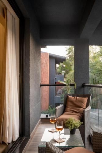 a balcony with a couch and a table and a window at 3BHK Villa With Private Pool & Concierge in Asagao in Assagao