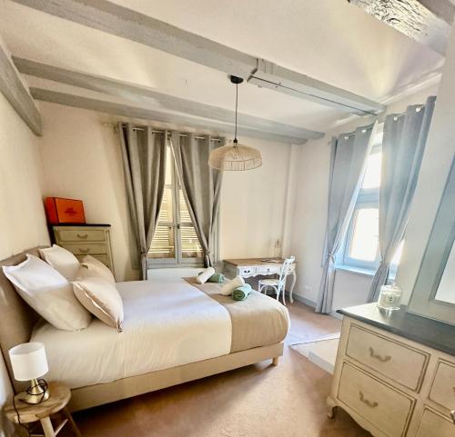 une chambre avec un lit, une table et des fenêtres dans l'établissement Limoges Centre Appartement de Charme, à Limoges