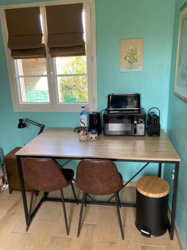 Il comprend une cuisine équipée d'une table avec deux chaises et d'un four micro-ondes. dans l'établissement Chez Liselotte, à Borgo