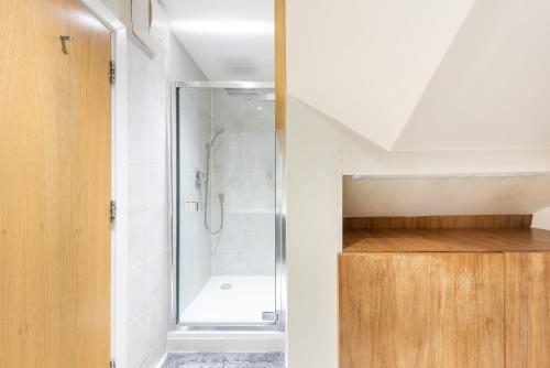een badkamer met een douche en een houten kast bij Park Home near Portobello Road - Raised Ground Floor - WiFi - Washing Machine in Londen