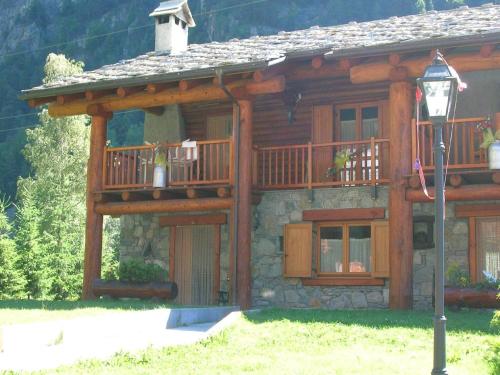 a log cabin with a balcony and a street light at Chalet village situated in a quiet area in Antey-Saint-André