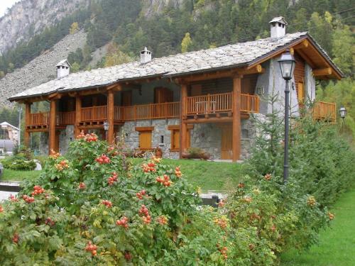 a large wooden house with a balcony in a yard at Chalet village situated in a quiet area in Antey-Saint-André